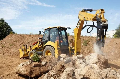 Tracked excavator with hydraulic rock breaker excavating hard rock strata