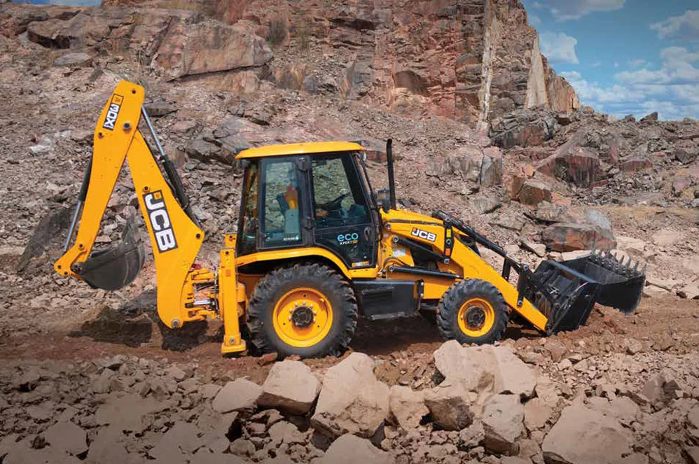 Front loader shovel grading plot and loading construction debris into tippers
